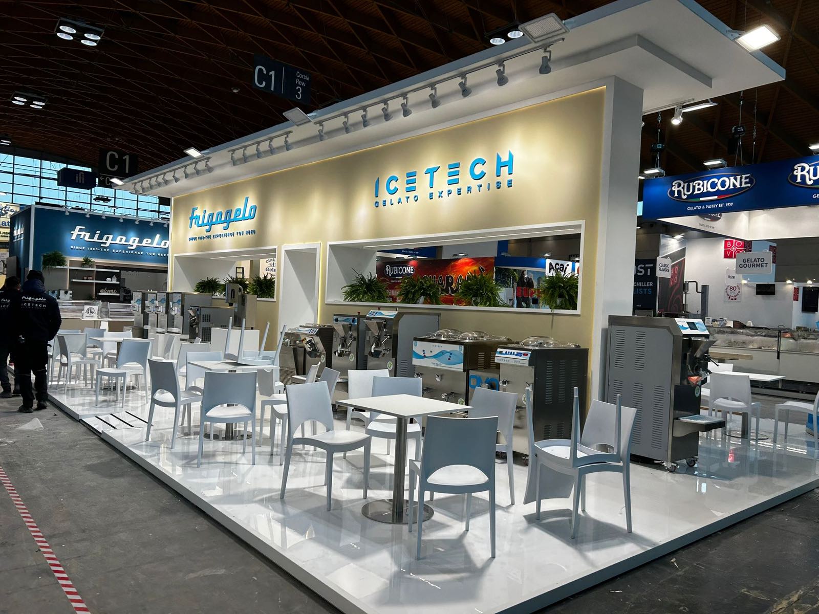 Area incontri con tavoli e sedie bianche davanti alla parete Frigogelo e Icetech