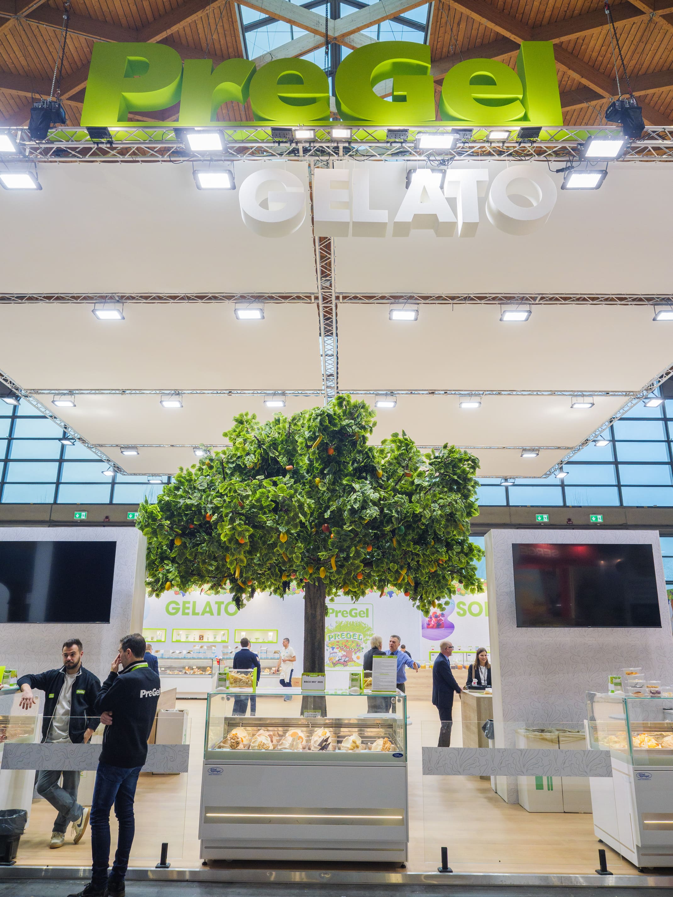 Ingresso dello stand PreGel con albero di arance, vetrine del gelato e logo sospeso