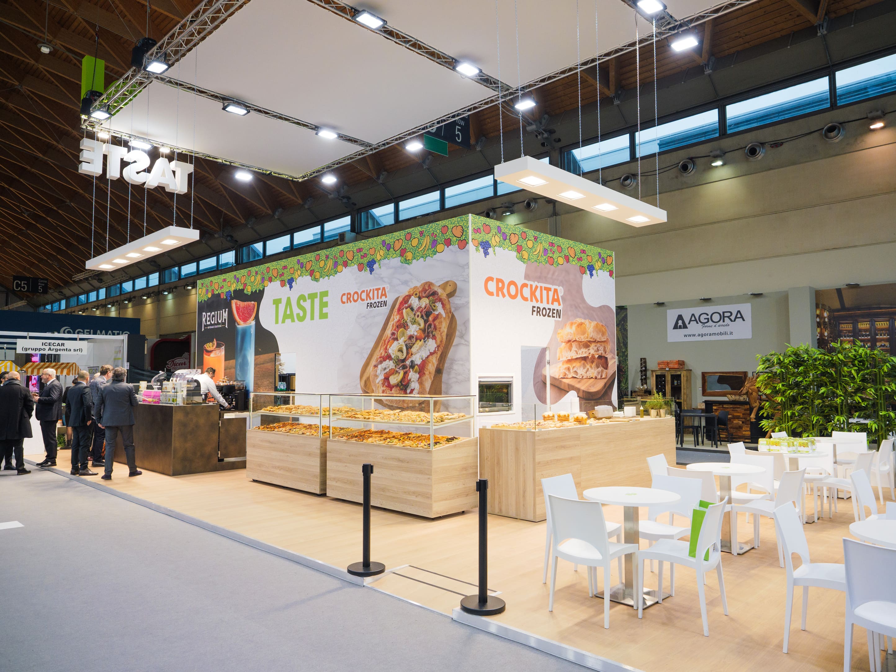 Zona TASTE Crockita dello stand PreGel con banchi in legno e area tavoli