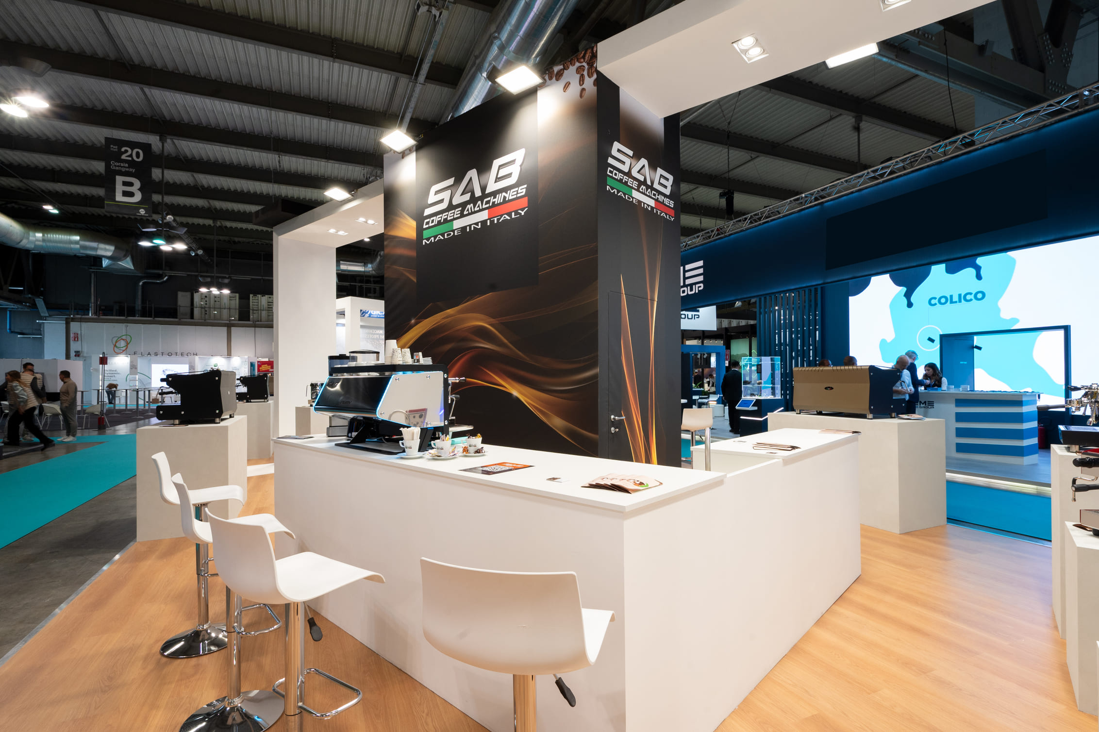 Banco bar bianco con macchina da caffè e sgabelli nello stand Sab Coffee Machines